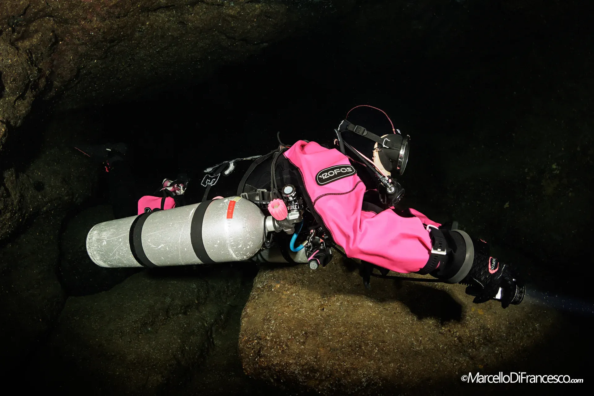 Passaggio stretto in una caverna con subacquea in sidemount