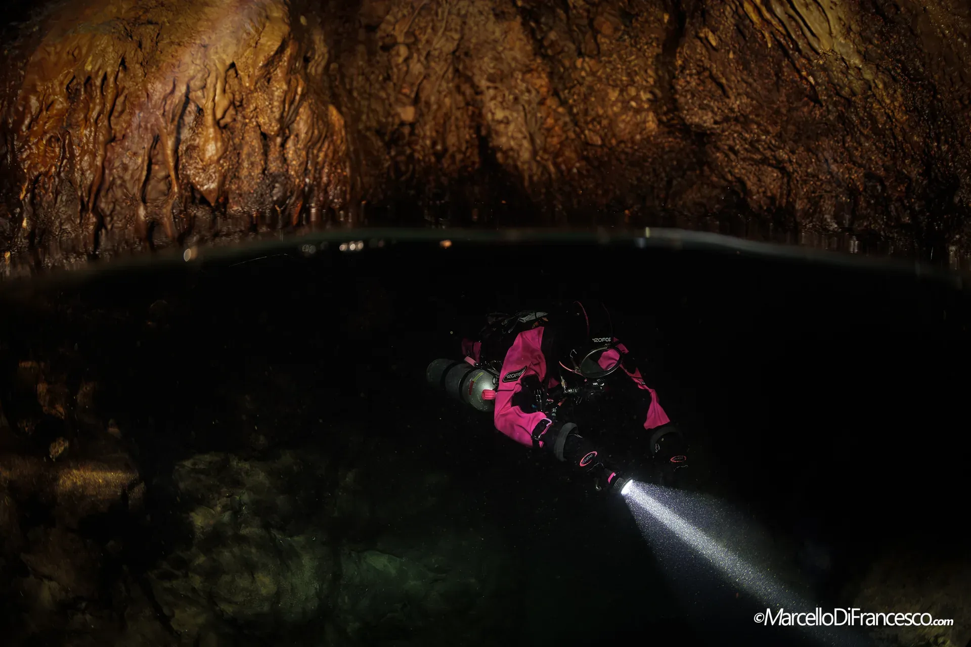Subacquea tecnica con torcia in una caverna a Portofino